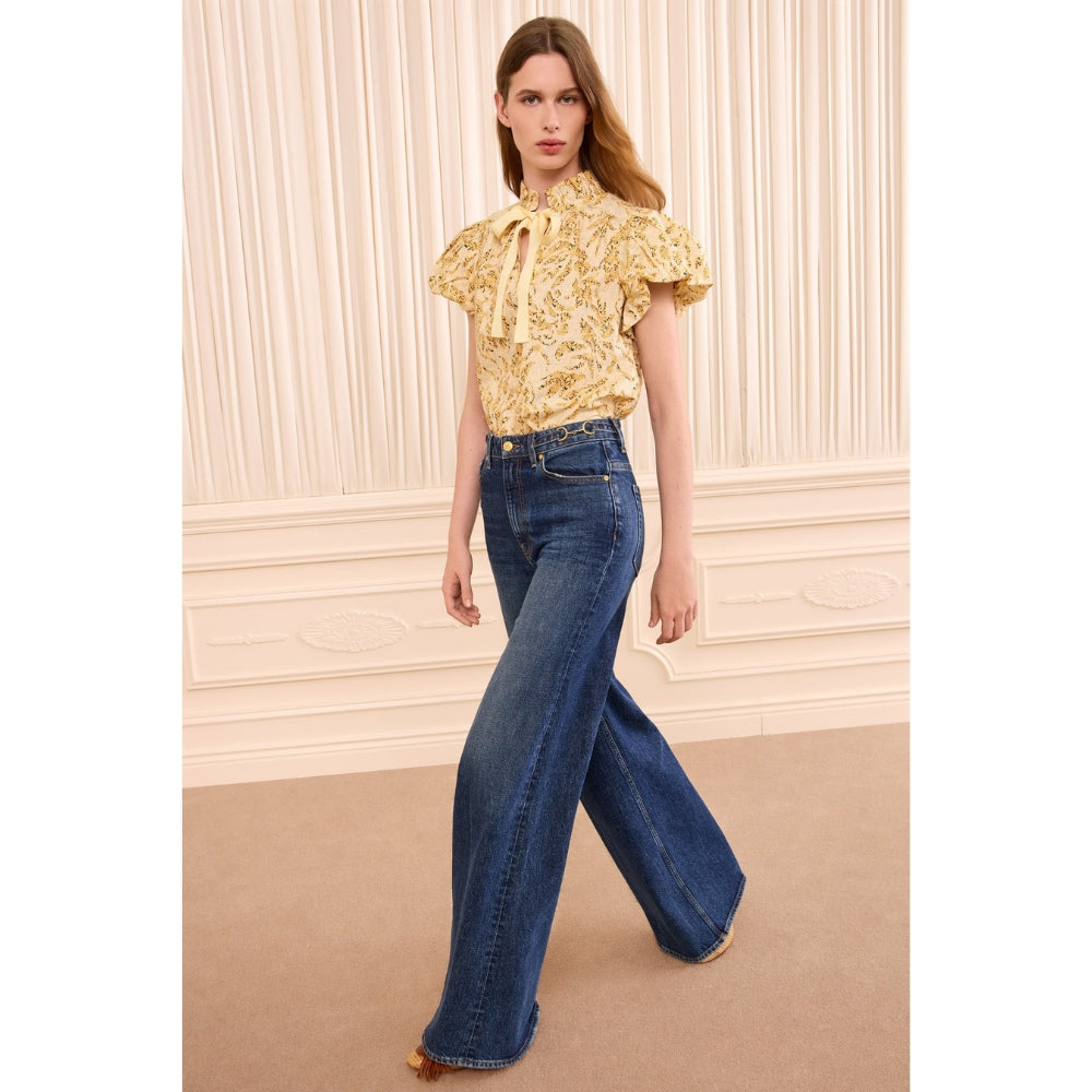 Riada Concept Ulla Johnson Estela cotton poplin top in a pale yellow print, with bubble sleeves and a ruffled tie neck - model front view