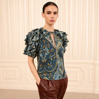 Riada Concept Ulla Johnson Josephine silk crepe de chine top in a blue paisley print, with ruffled sleeves and a tie neck - model front view