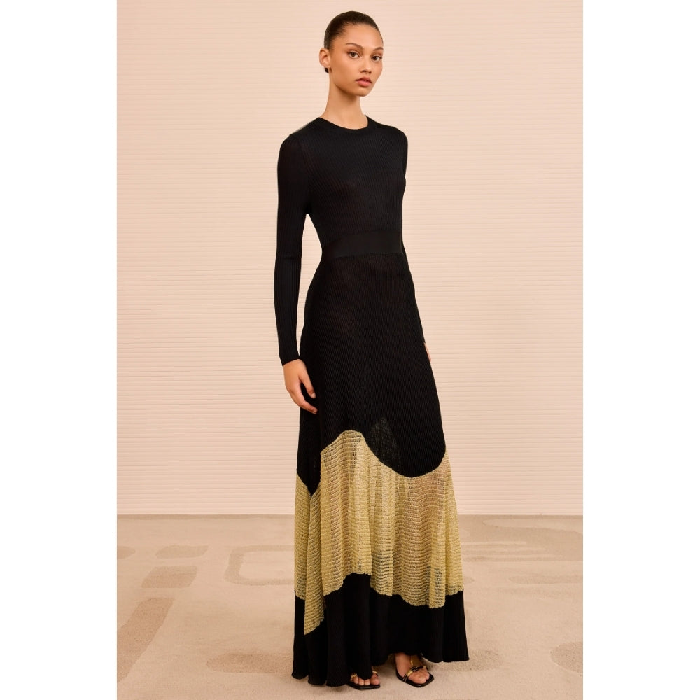 Shop Ulla Johnson Roanne in Gold Noir, a slim rib-knit long dress with shimmering Lurex mesh hem, crew neck and fluid ankle-grazing skirt at Riada.