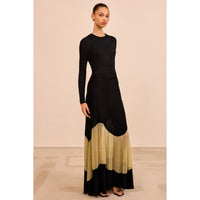 Shop Ulla Johnson Roanne in Gold Noir, a slim rib-knit long dress with shimmering Lurex mesh hem, crew neck and fluid ankle-grazing skirt at Riada.