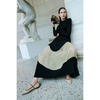 Shop Ulla Johnson Roanne in Gold Noir, a slim rib-knit long dress with shimmering Lurex mesh hem, crew neck and fluid ankle-grazing skirt at Riada.