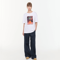 Plan C Vase Print Cotton T-Shirt in Optical White with multicolour floral vase artwork styled on model with relaxed black trousers
