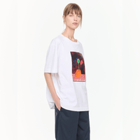 Plan C Vase Print Cotton T-Shirt in Optical White with multicolour floral vase artwork styled on model with relaxed black trousers - angled view