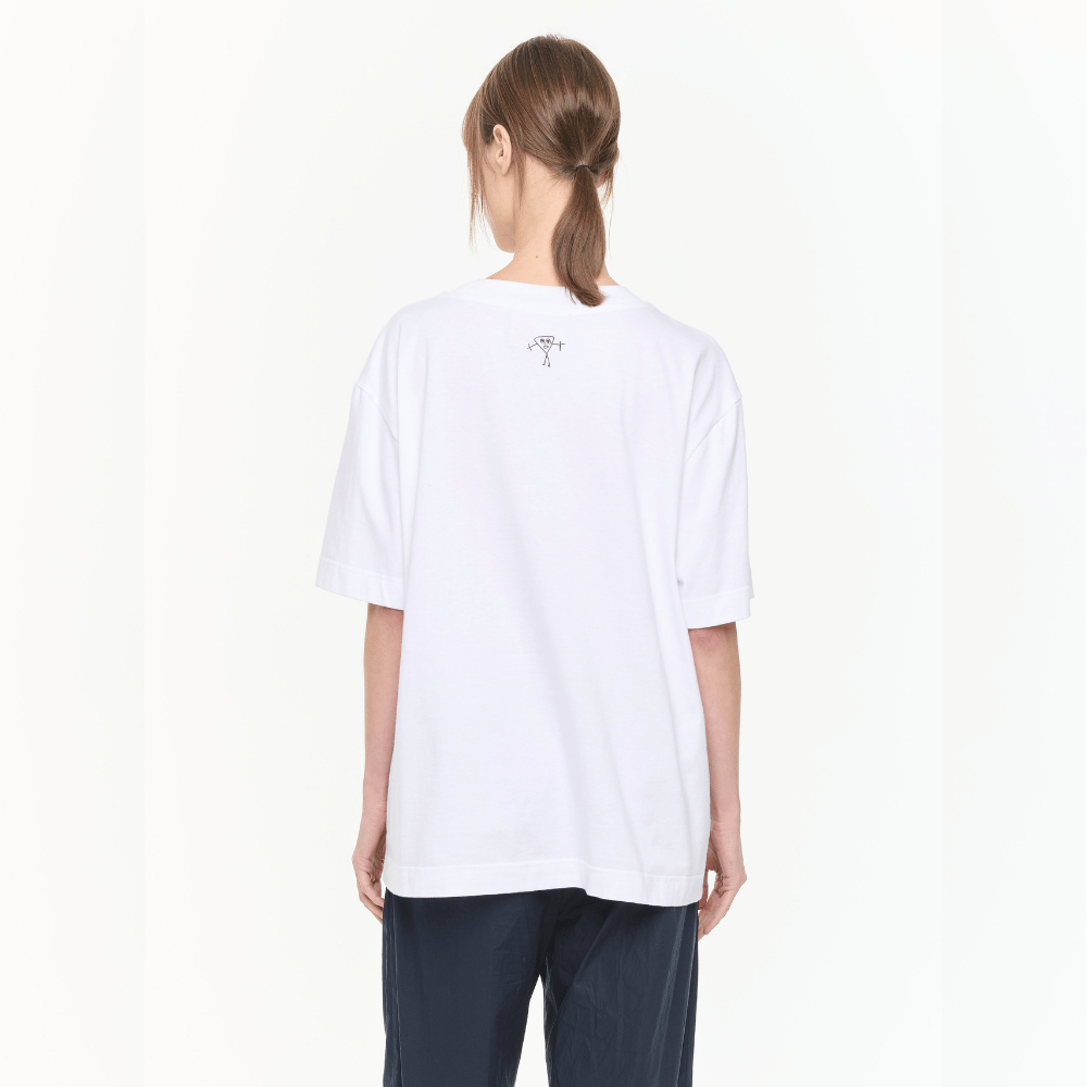 Plan C Vase Print Cotton T-Shirt in Optical White with multicolour floral vase artwork styled on model with relaxed black trousers - back view