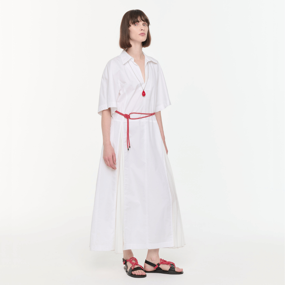 Plan C Optical White pleated shirt dress styled with Vermilion Red necklace and cord sandals - angled view