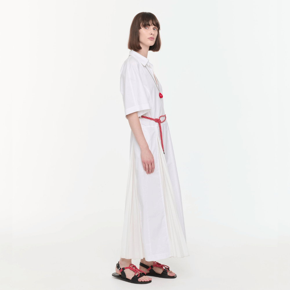 Plan C Optical White pleated shirt dress styled with Vermilion Red necklace and cord sandals - side view